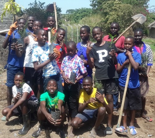 The UNIFAT team holding saplings ready for planting. Peter is at the back on the right wearing a red shirt.